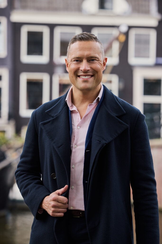 Elwin van Dulst, makelaar and founder of Canal City Realty, in front of a canal house in Amsterdam