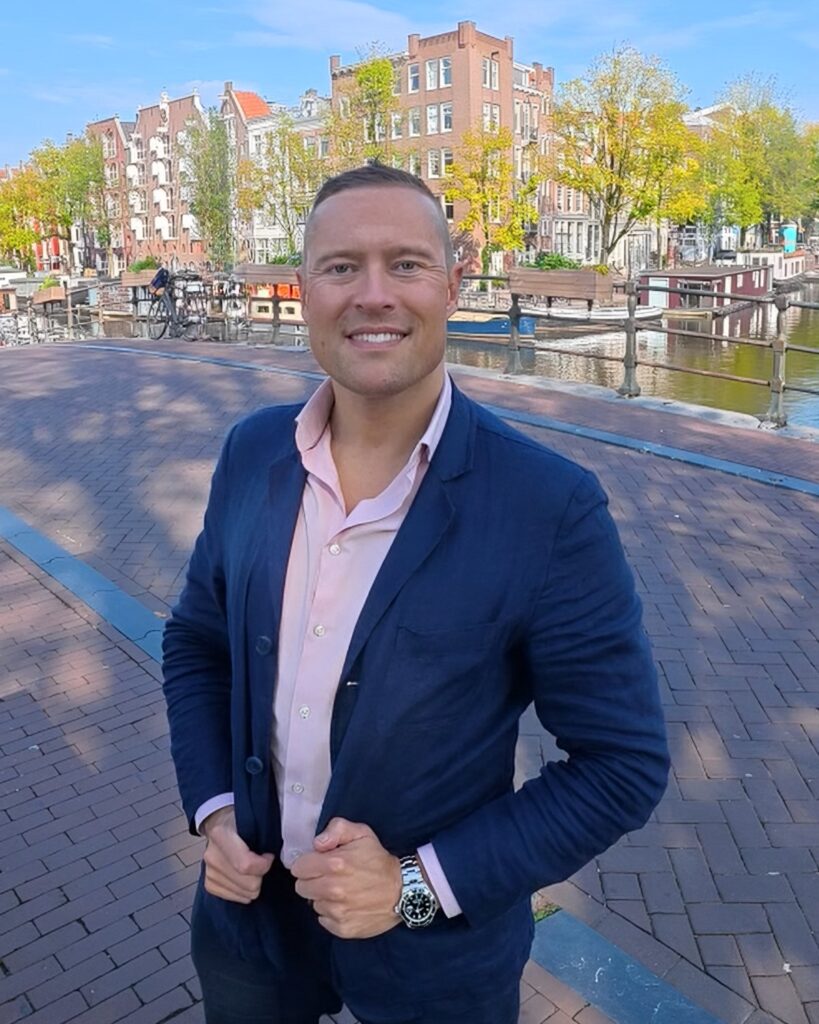 Elwin van Dulst, makelaar and founder of Canal City Realty, on a canal bridge in Amsterdam